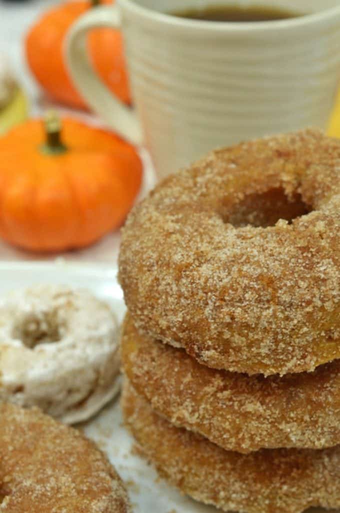 A close up of pumpkin doughnuts and a cup of coffee, with Pumpkin 