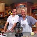 Two men standing in a kitchen.