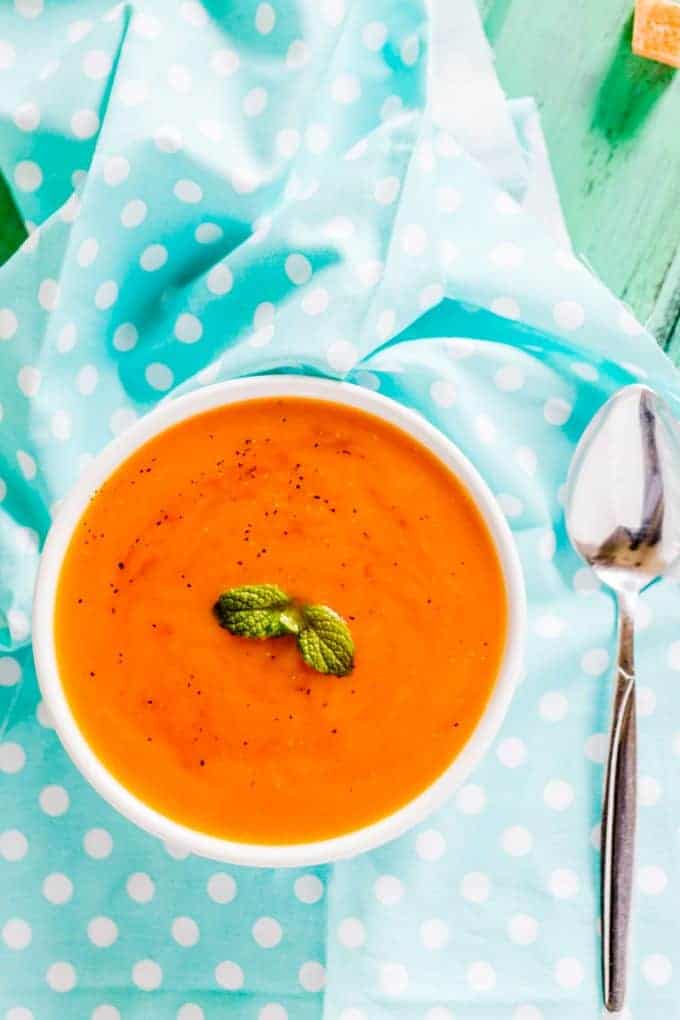 A bowl of sweet potato soup and a spoon