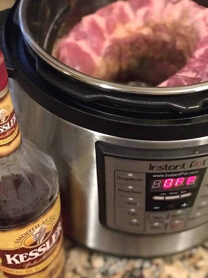 Ribs in Instant Pot next to bottle