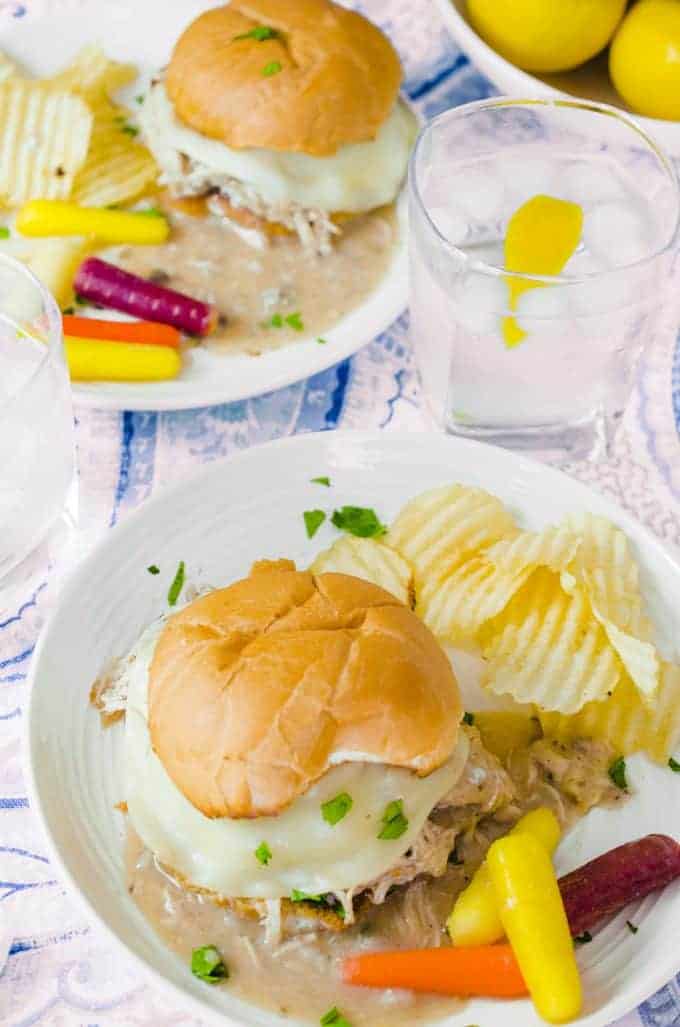 Ariel view plates holding hot turkey bun sandwich with chips and veggies on side