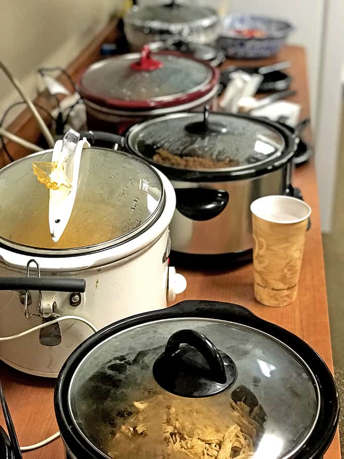 Crockpots lined up for a pot luck dinner.