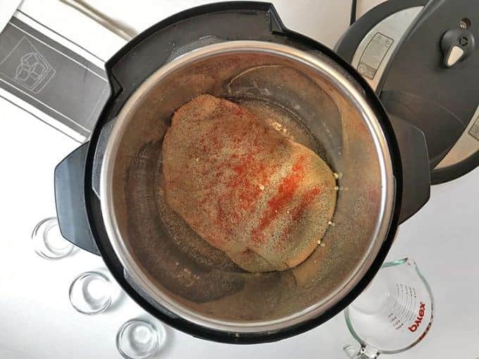 Ariel view of open instant pot containing seasoned turkey breast