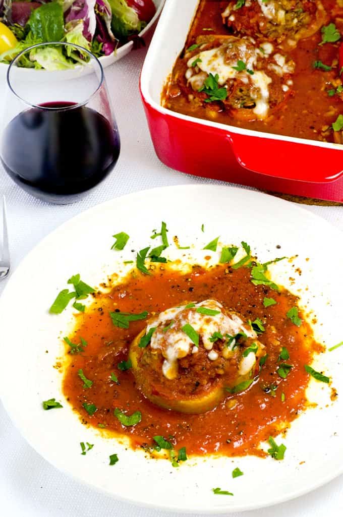 A bowl of food on a plate, with Stuffed peppers and Bell pepper