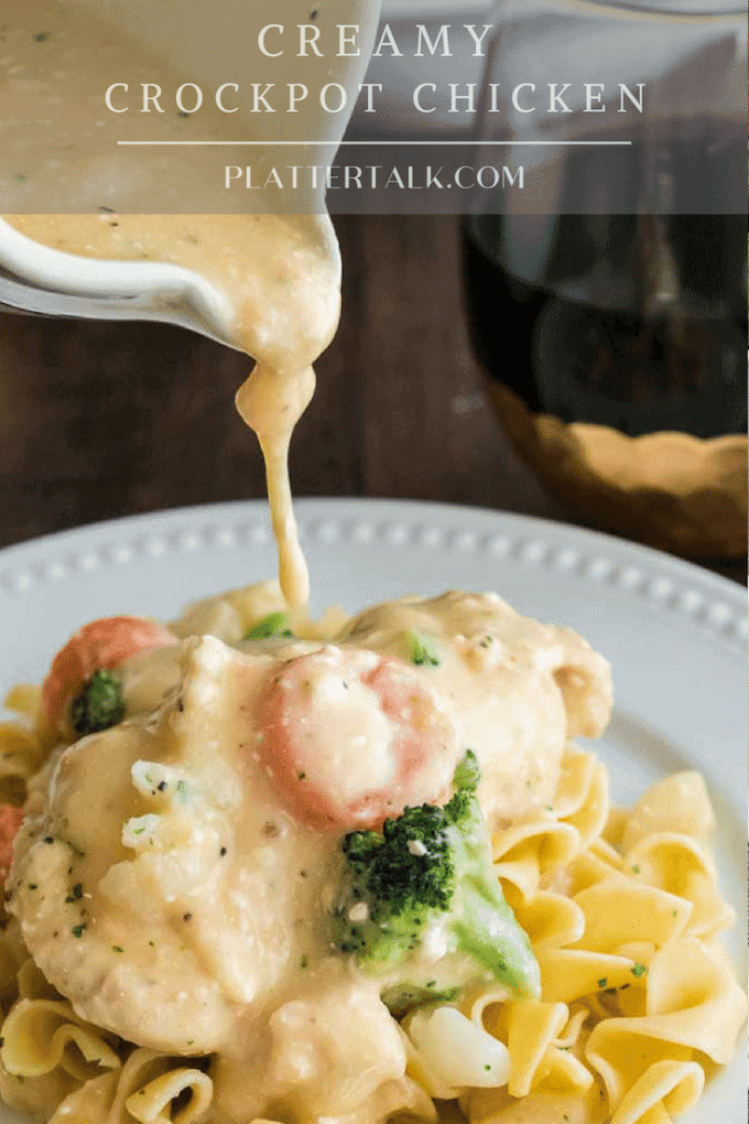 Someone pouring sauce atop noodles with vegetables