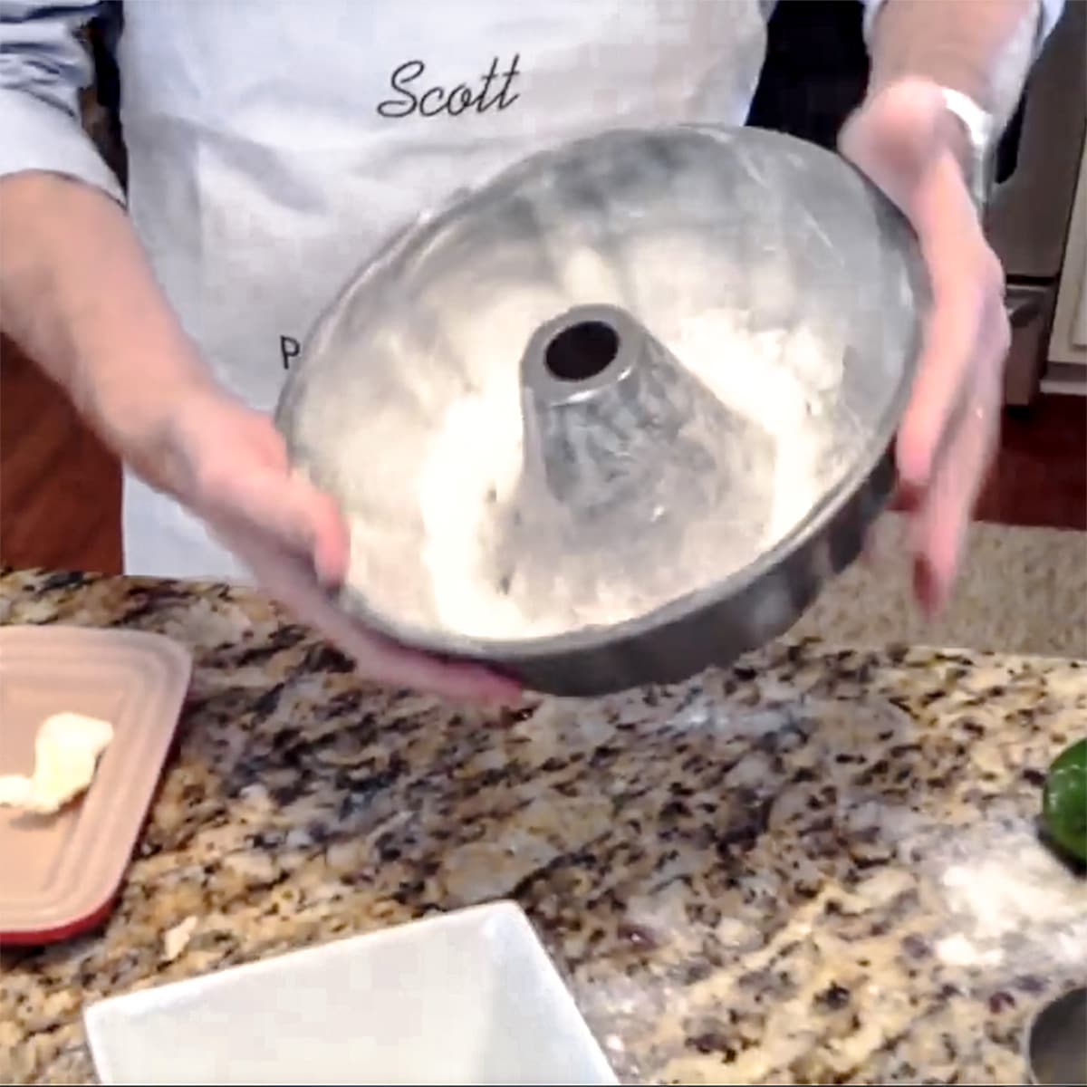 A bundt cake pan beging dusted with flour.