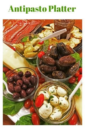 Antipasto of olives, dates, cheese, artichokes and crackers on table