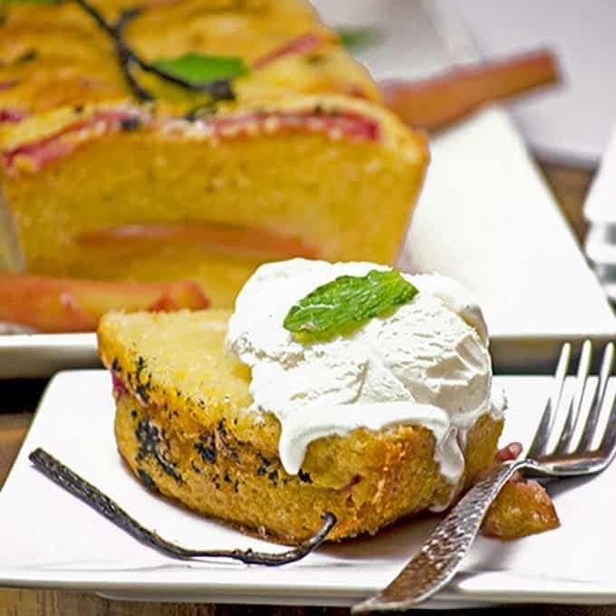 A piece of pound cake on a plate, with ice cream and mint
