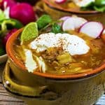 Sour cream and lime wedges add extra flavor to this posole recipe.