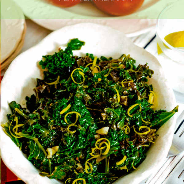 Bowl of steaed kale with lemon zest garnish.