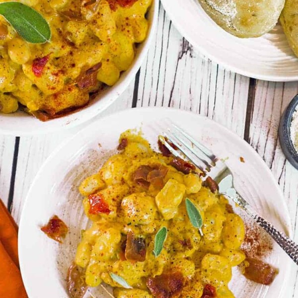 Pumpkin gnocchi on plate with fork and in serving bowl