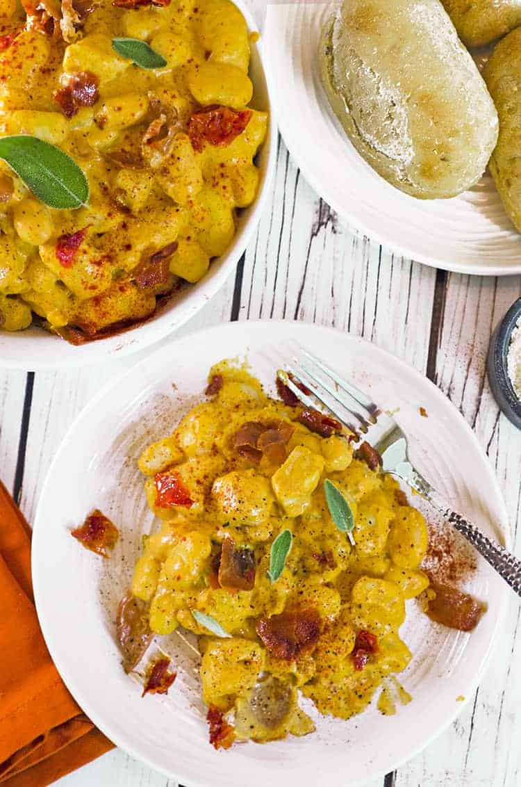 Pumpkin gnocchi on plate with fork and in serving bowl