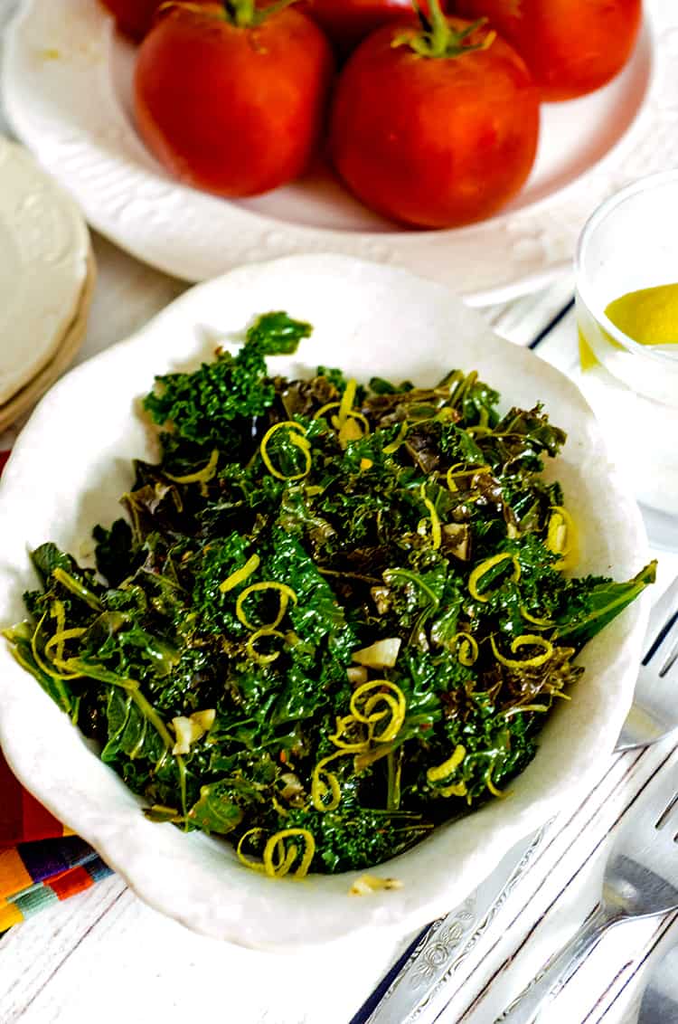 Bowl of steamed kale with lemon zest garnish.