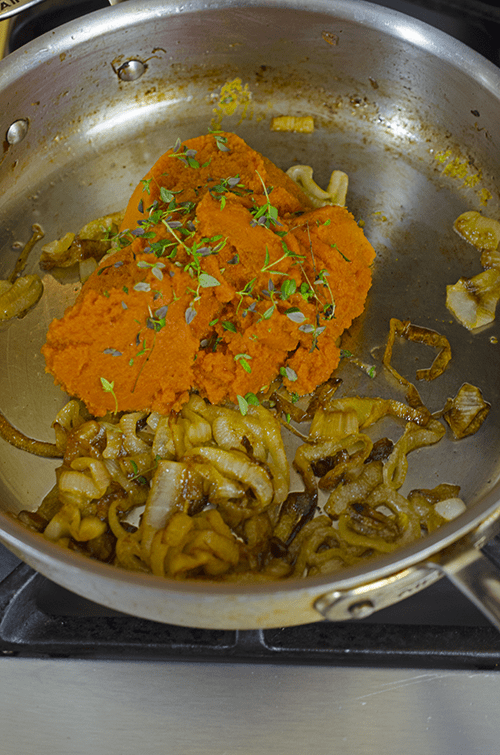 Caramelized onion, with pumpkin puree and fresh herbs in saute pan