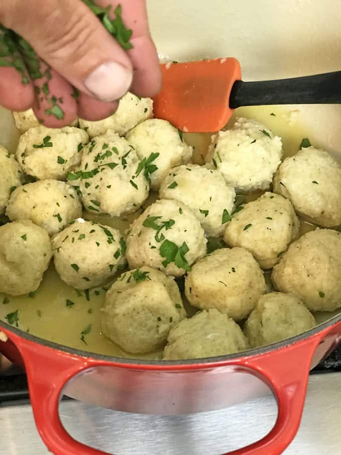Addding fresh herbs to potato dumplings.