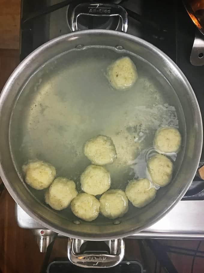 Potato dumplings rise to the top of the hot water.