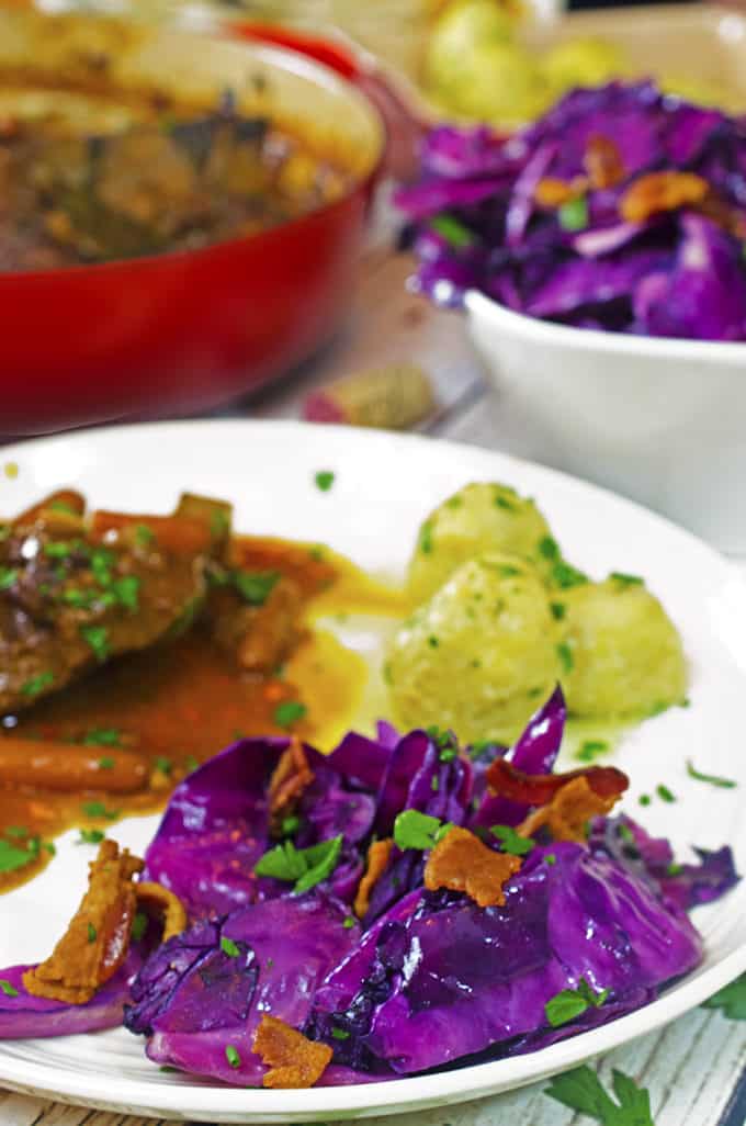 Dinner plate filled with fried cabbage, pork, and potato dumplings.