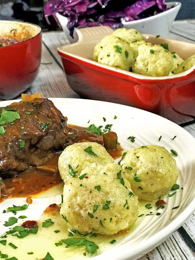 Dinner plate of potato dumplings and braised pork shoulder.