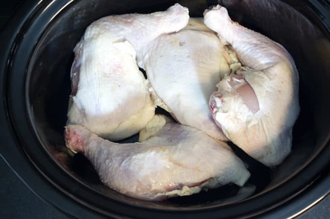 Uncooked chicken thighs in a crock-pot.