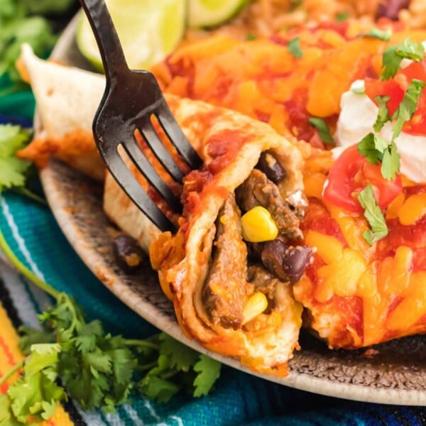 Using a fork to eat an enchilada made with leftover steak.