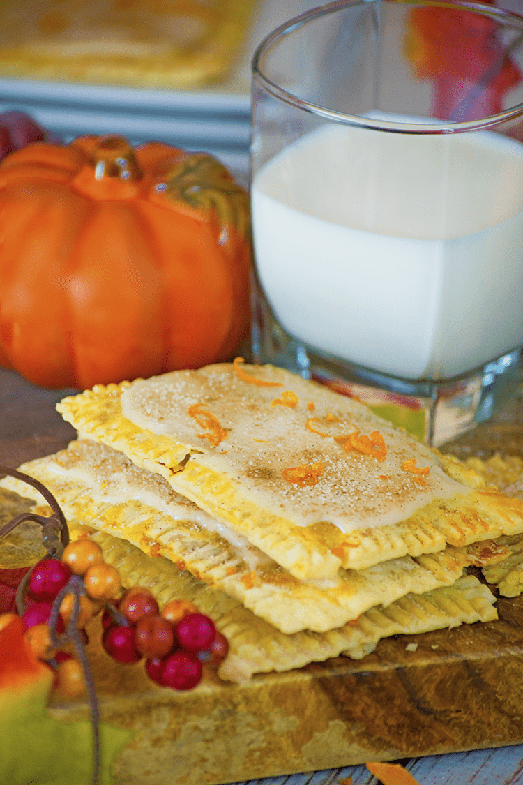 Pop tarts, glass of milk and pumpkin on wood