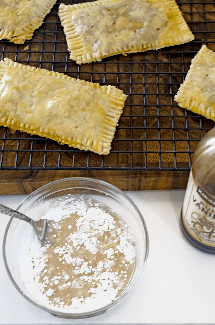 Pop tarts on cooling rack with bottle and glass bowl icing 