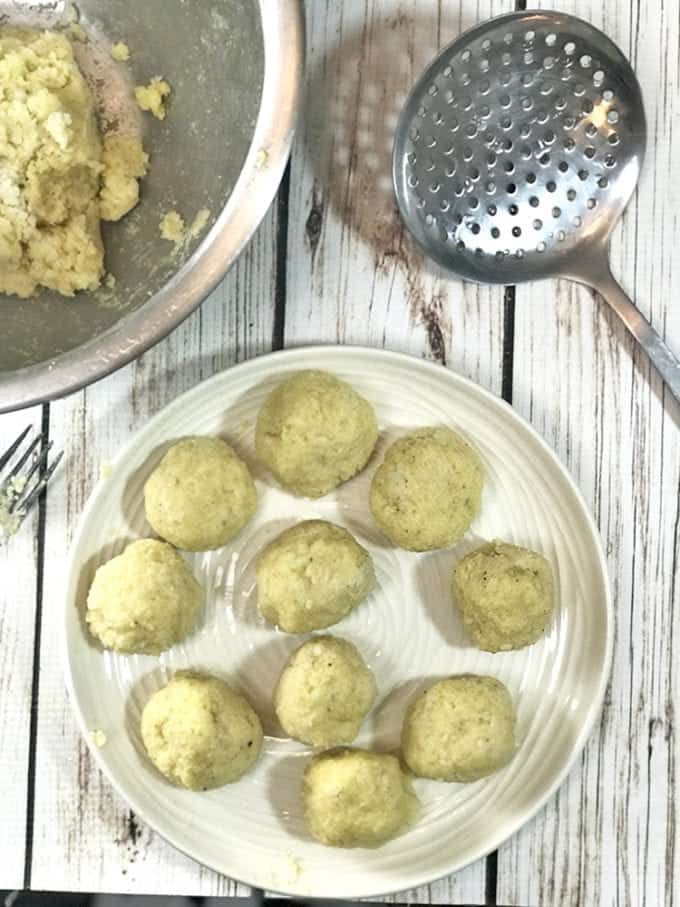 Rolling out potato dumplings the size of golf balls.