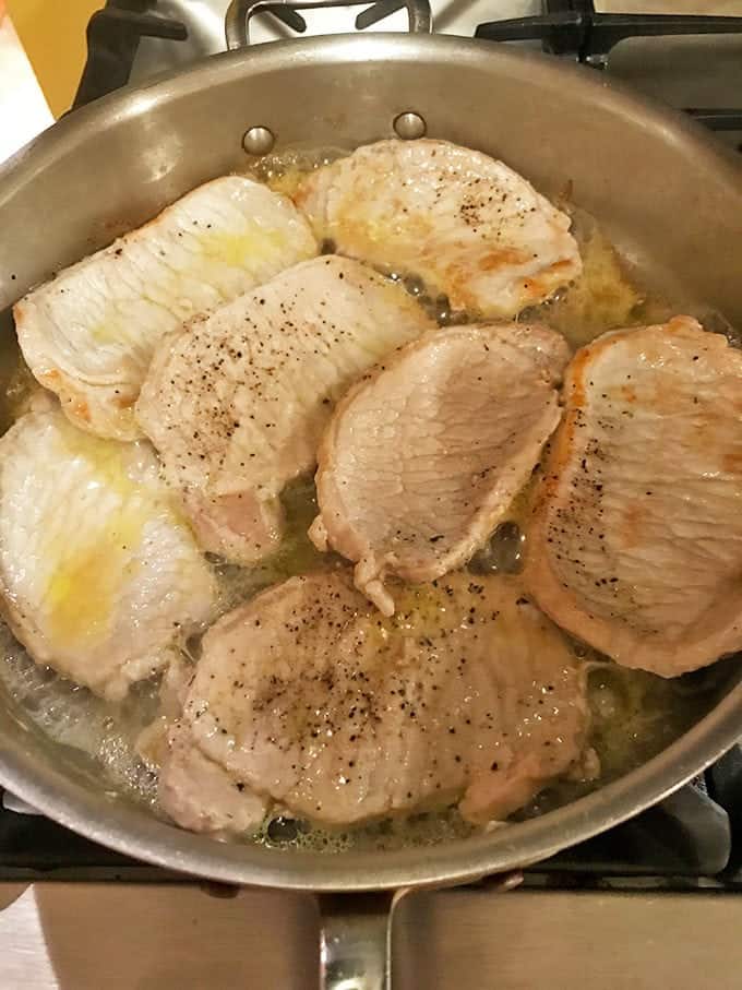 Sauteing seasoned pork in skillet