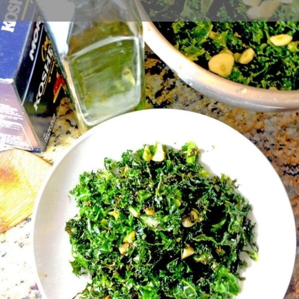 white plate of roasgted kale with olive oil and kosher salt.