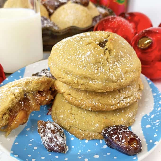 A stack of Christmas cookies with dates on a plate