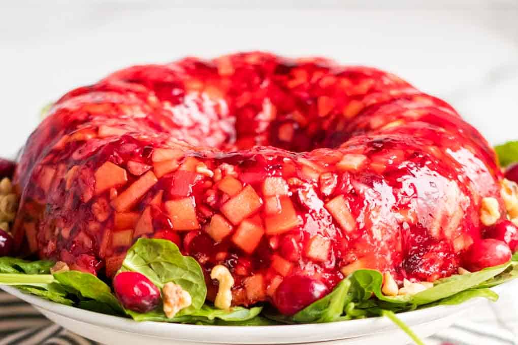 Cranberry jello salad on a servimg plate.
