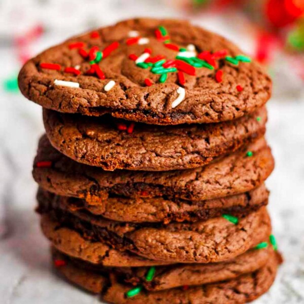 A stack of chocolate cookies with sprinkles on top.