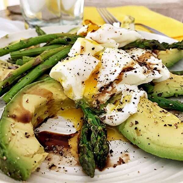 A close up of a plate of food with asparagus, with Avocado and Egg