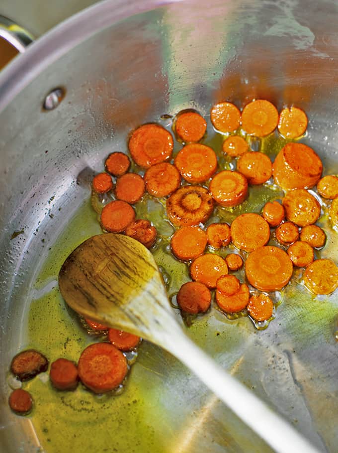 A skillet of carrots being sauteed