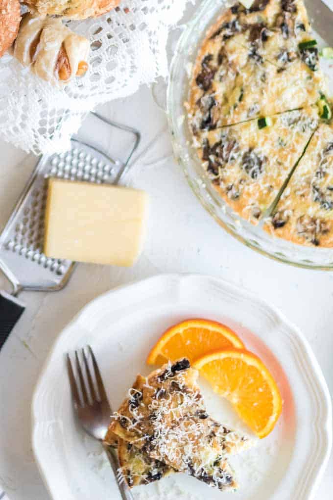 A plate of food with a slice of cake on a table, with Quiche