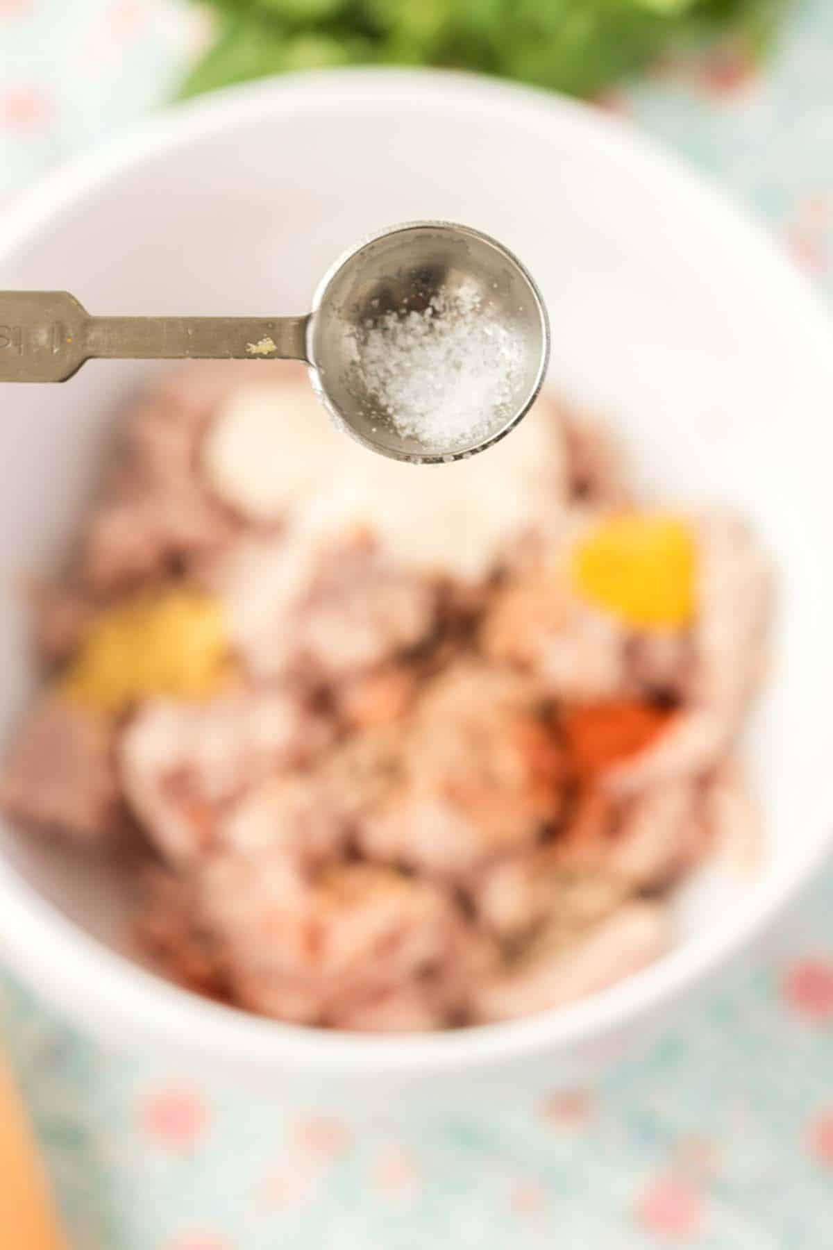 Adding salt and pepper to some deviled ham mixture.