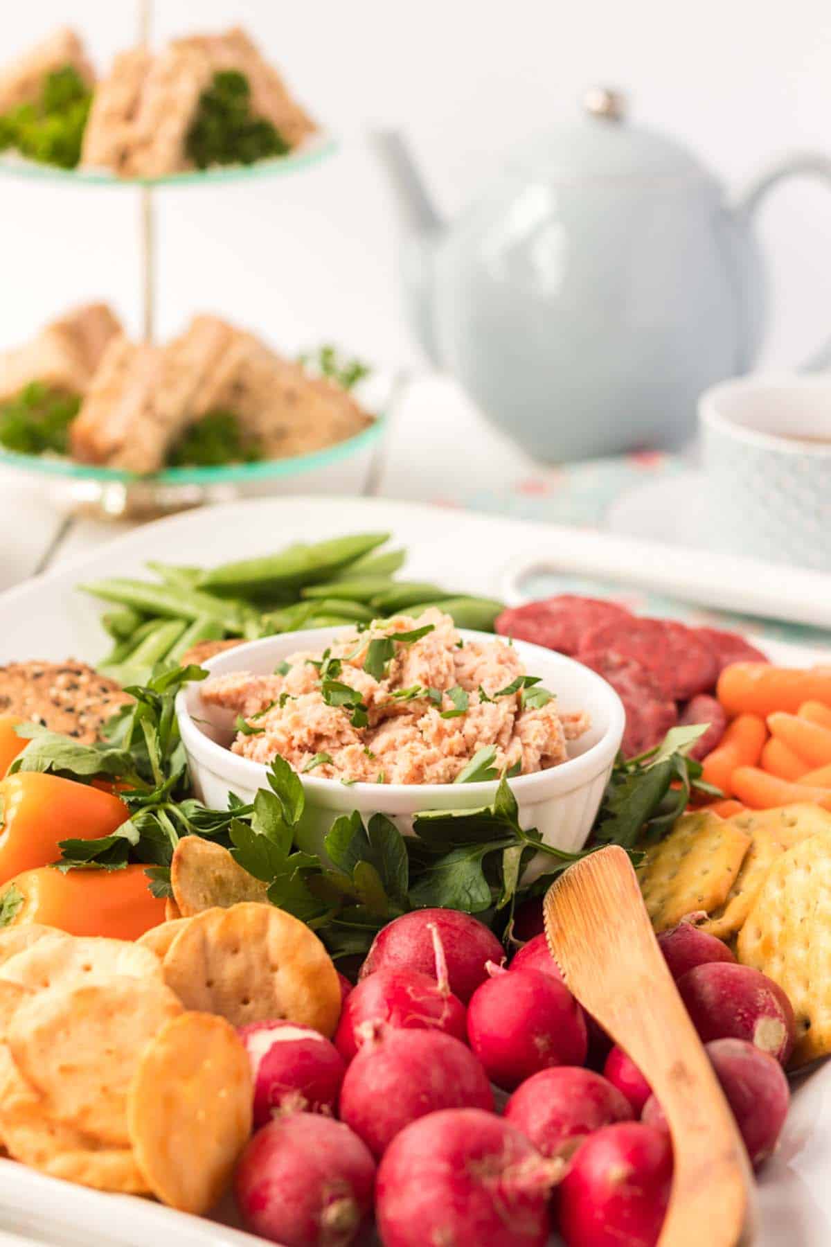 A bowl of deviled ham with a bunch of veggies and crackers.