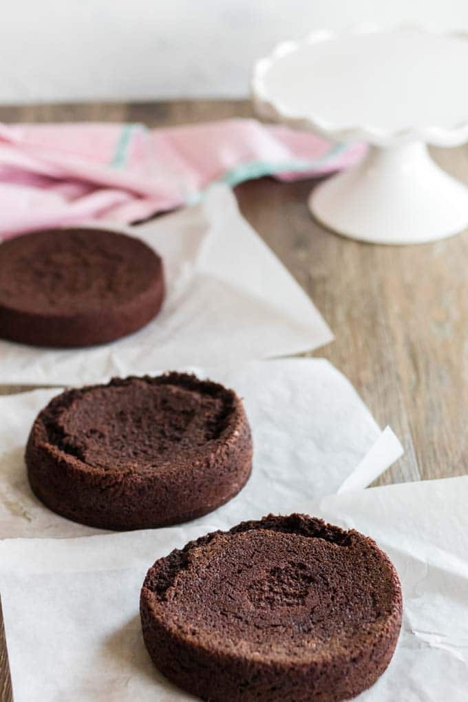 Three layers of a chocolate cake, sitting on paper towels