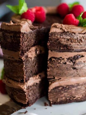 A close up of a chocolate cake with a piece cut from it