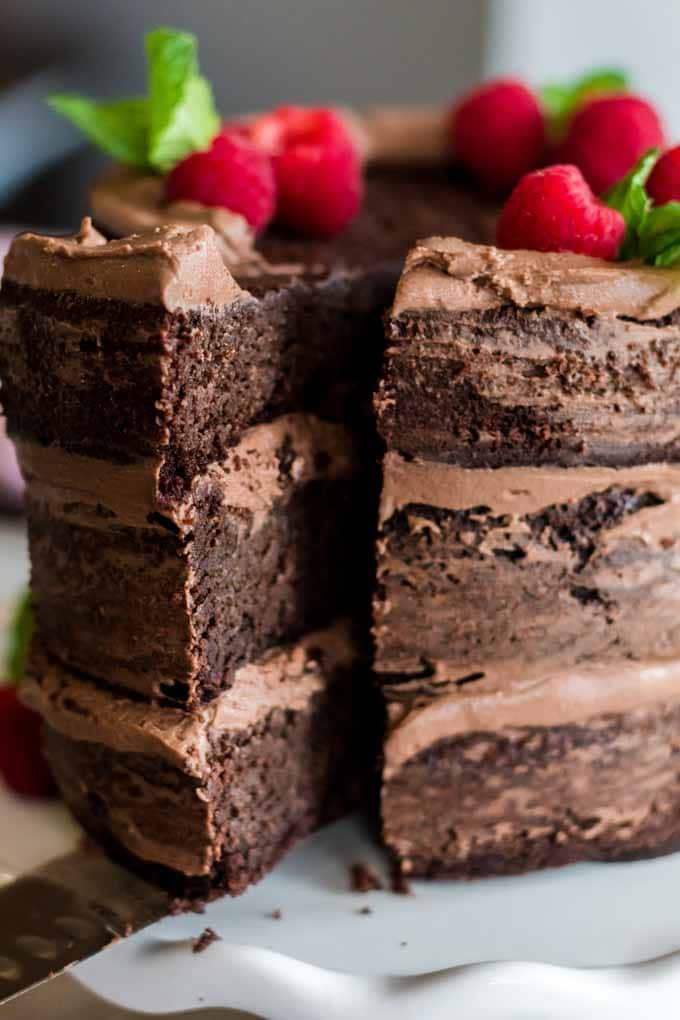 A close up of a chocolate cake with a piece cut from it