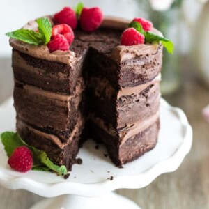 A tall chocolate cake topped with raspberriews