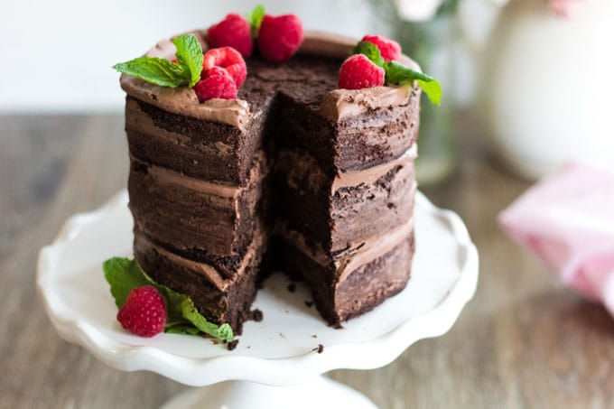 A tall chocolate cake topped with raspberriews