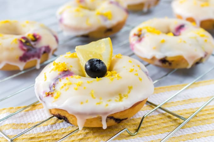 Baked donuts with lemon glaze on a wire rack.