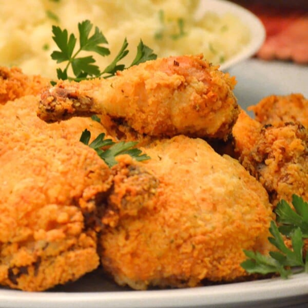 Plate of oven-fried chicken with parsley garnishes.