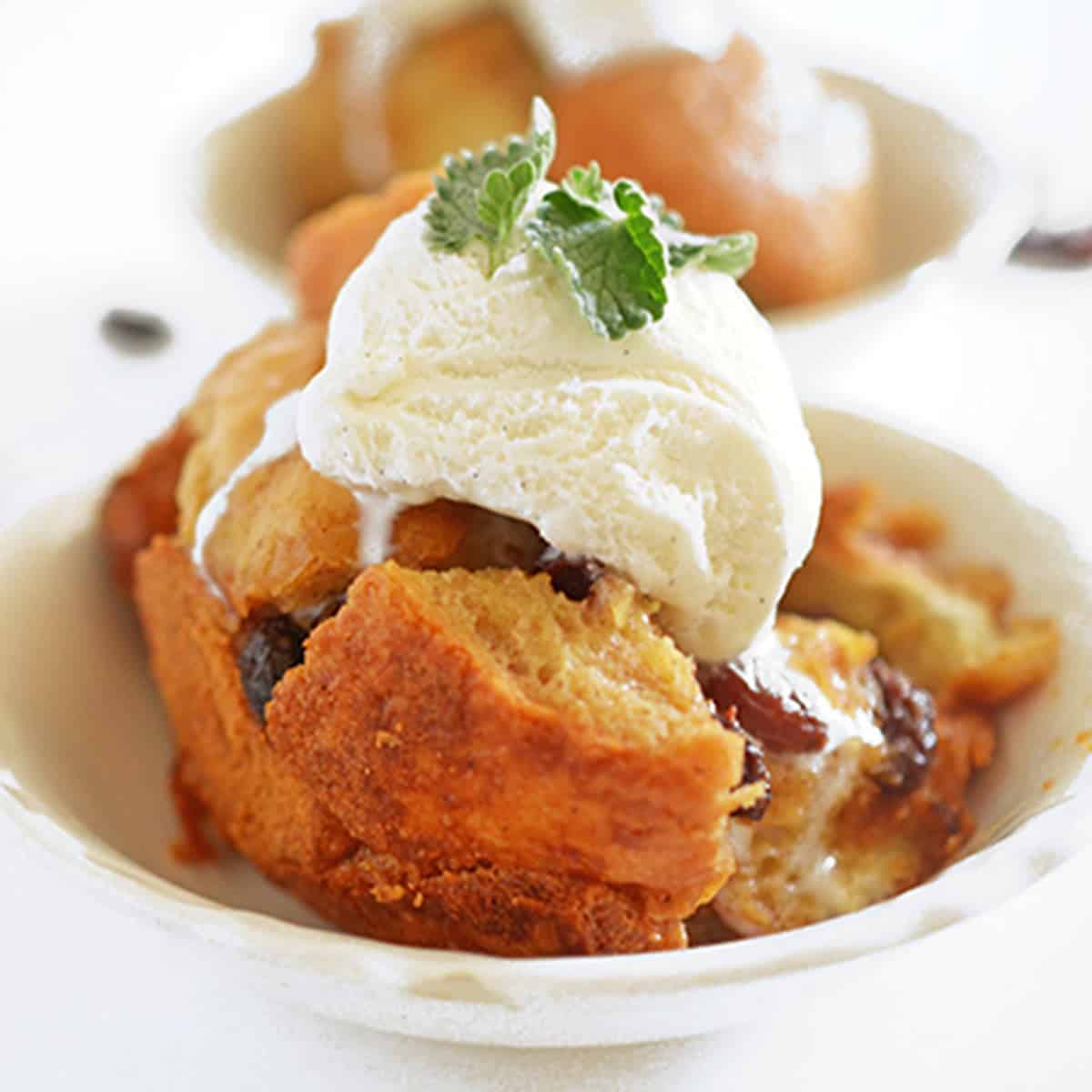 A bowl of bread pudding with vanilla ice cream on top