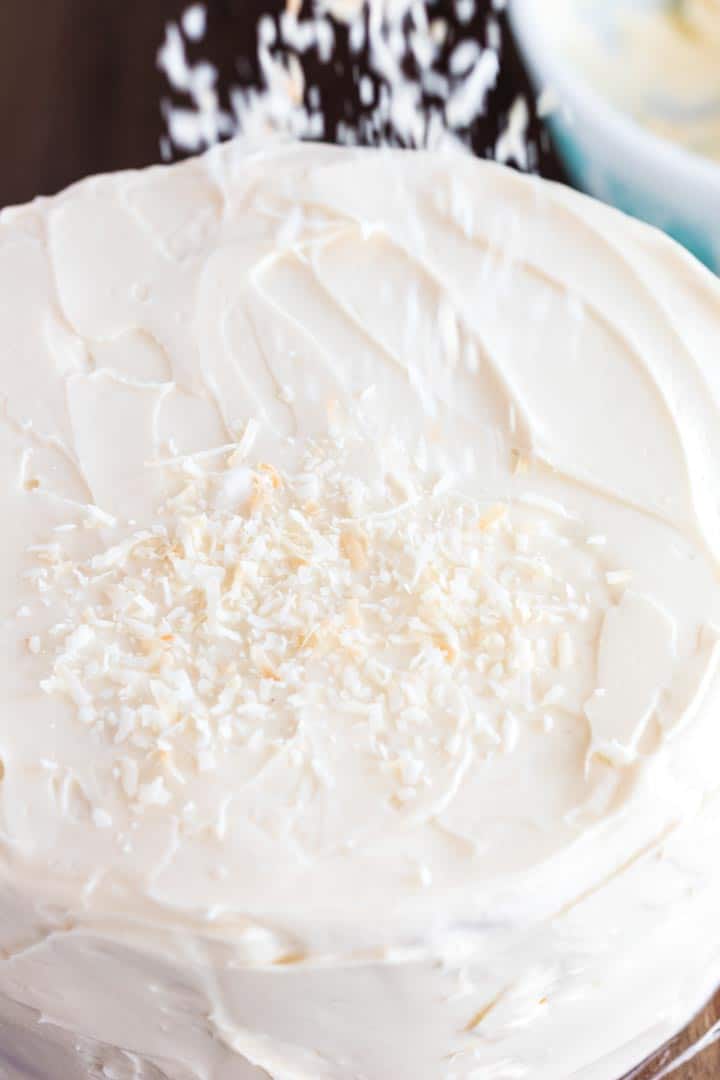 Sprinling coconut flakes. over carrort cake and cream cheese frosting.