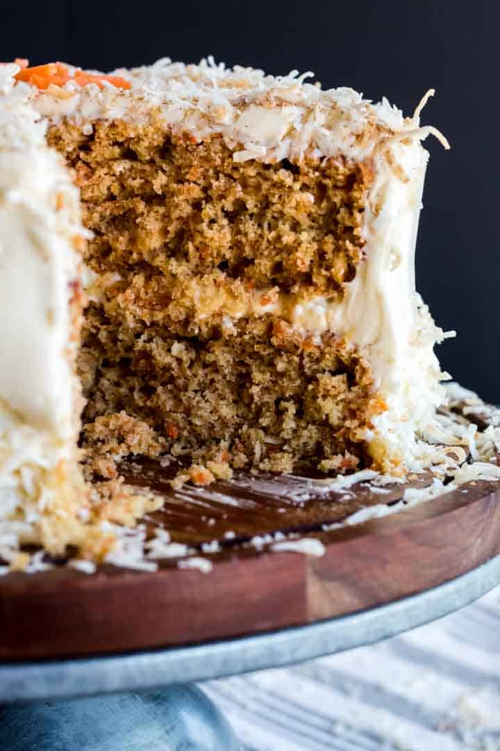 coconut carrot cake sliced open, showing rich layers of crumbs and frosting.