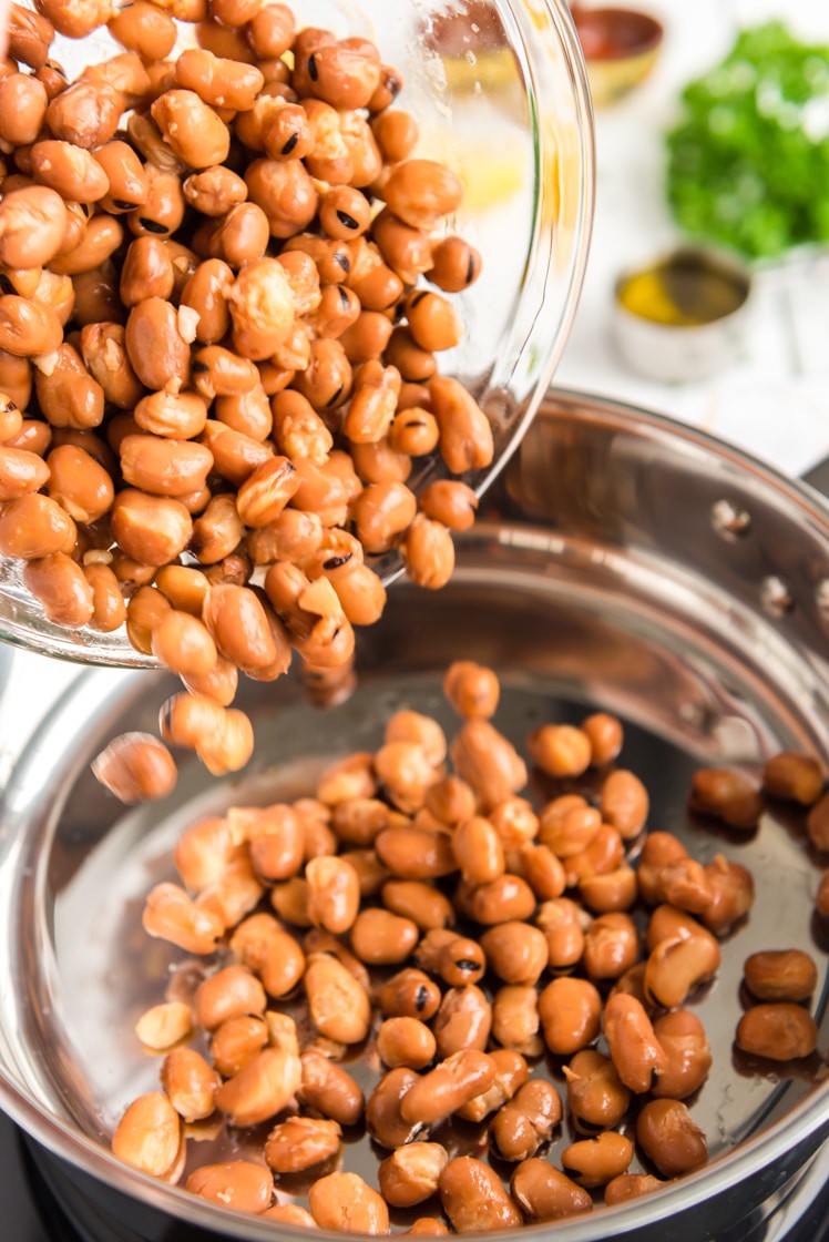 Fava benas being drained and rinsed.