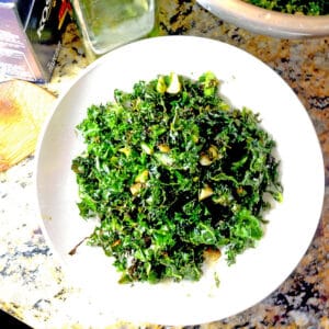 A plate of dark green roasted kale on a white plate.