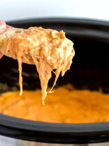 Scoop of buffalo wing dip on a nacho chip.